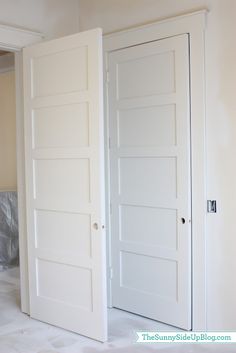 an empty room with two white doors in it