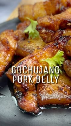 some food is sitting on a plate with the words gochujuang pork belly