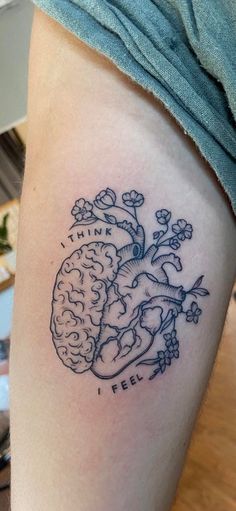 a tattoo on the leg of a woman with a heart and brain in it's center