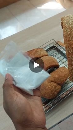 a person is holding some bread on a rack