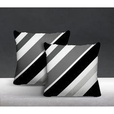 two black and white striped pillows sitting on top of a bed next to each other