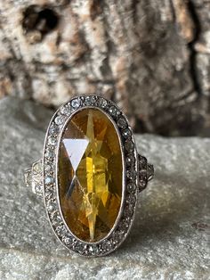 A wonderful vintage Art Deco ring, a lovely oval faux Citrine surrounded by sparkling faux Diamonds in a silver setting with an overall size of 22mm x 13mm on a 9ct gold band with classic stepped shoulders , Size L or US 5.5 Vintage Art Deco Rings, Unusual Earrings, Deco Ring, Diamond Solitaire Rings, Art Deco Ring, Garnet Rings, Multi Stone Ring, Gold Band, Cluster Ring