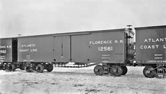 an old black and white photo of three train cars on snow covered ground in the middle of winter