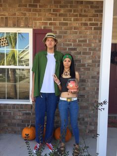 a man and woman standing in front of a house with pumpkins on the porch