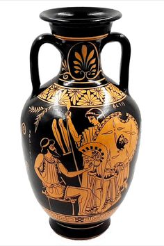 an old black and gold vase with figures on it's sides, sitting against a white background