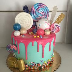 a colorful cake with candy and lollipops on top