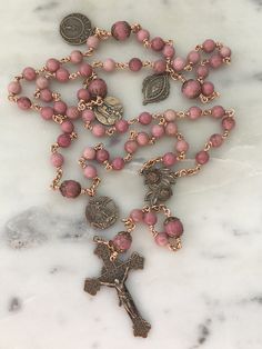 This is a beautiful wire-wrapped heirloom rosary! Beads: 6.5 and 8mm rhodonite gemstones Medals: Bronze Wire: 20 gauge solid bronze Extra medals: OL of Sorrows Saint Michael Sacred Heart Stella Maris Mac Aesthetic, Pink Rosary, Sacred Space Altar, Jesus Piece, Rosary Beads Catholic, Catholic Decor, Pink Rhodonite, Gold Rosary, Stella Maris