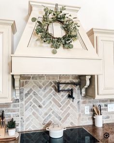 a kitchen stove top with a wreath on it's mantle above the rangetop