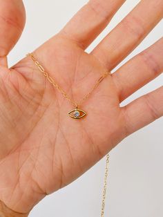 Petite gold CZ evil eye necklace pendant on gold filled chain. Gold fill charm with one tiny CZ in the center of the eye. Perfect dainty piece to wear alone or layer. Available 15” to 18” in length. Gold fill lobster clasp. Everyday Yellow Gold Evil Eye Charm Necklaces, Dainty Yellow Gold Evil Eye Charm Necklace, 14k Gold Evil Eye Charm Necklace, Gold Evil Eye Charm Necklace For Everyday, Everyday Gold Charm Necklaces With Evil Eye, Dainty 14k Gold Charm Necklace With Evil Eye, Everyday Gold Charm Necklace With Evil Eye, Gold Dainty Evil Eye Charm Necklace, Everyday Evil Eye Charm Necklaces