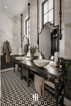 a black and white tiled bathroom with two sinks