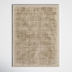 a beige area rug on a white wall