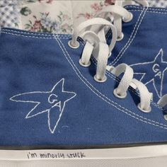 a pair of blue sneakers with white laces and an image of a pokemon on them