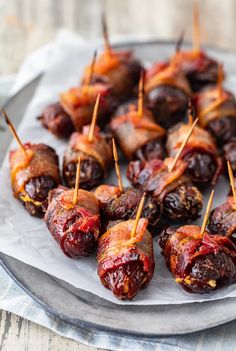 bacon wrapped dates with toothpicks on a plate