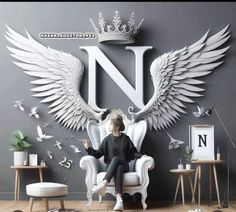 a woman sitting in a chair with wings on the wall