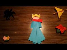 an origami paper doll and other items on a table