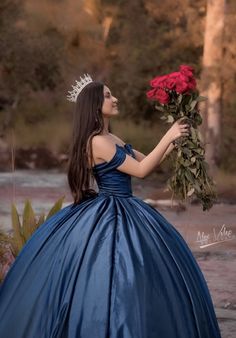 a woman in a blue dress holding a red rose