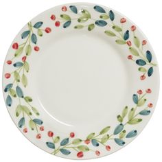 a white plate with red, green and blue leaves on it's rim is shown