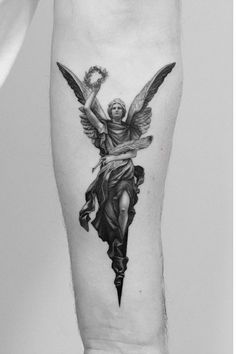 a black and white photo of a person with an angel tattoo on their leg,