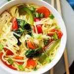 a white bowl filled with noodles and veggies