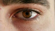 an extreme close up shot of a man's eye with brown eyeshadow