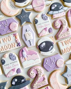 some decorated cookies are laying on a white tablecloth with the words two moon and stars