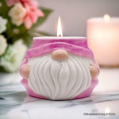 a white and pink candle holder with a santa claus face on it's side