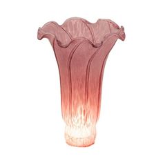 a pink vase sitting on top of a white table next to a wall mounted light