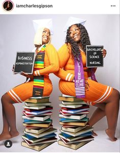 two women sitting on top of stacks of books holding signs that say no to racism