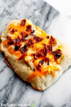 an uncooked pizza sitting on top of a marble counter