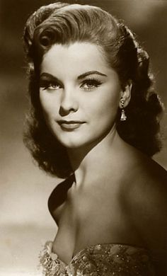 an old black and white photo of a woman in a dress with her hair up