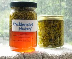 two jars filled with honey sitting on top of a window sill next to each other