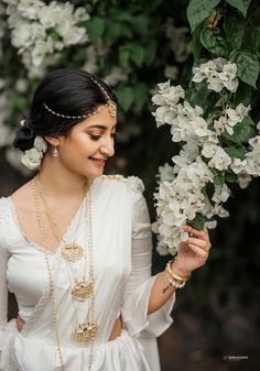 a woman in a white dress holding flowers