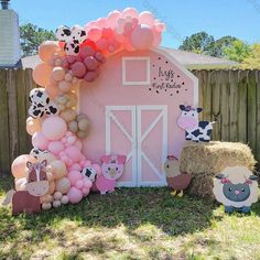 a pink barn decorated with balloons and farm animals