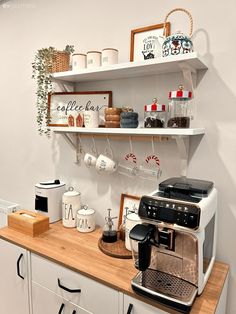 a coffee maker on top of a counter next to some shelves with cups and mugs