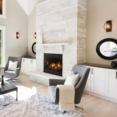 a living room filled with furniture and a fire place in the middle of it's wall