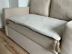 a white couch sitting on top of a hard wood floor