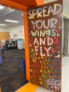 a sign that says spread your wings and fly on the side of a door in an office