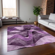 a living room with white couches and a purple area rug on the hardwood floor