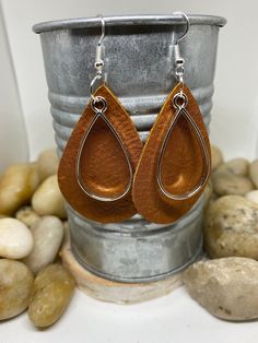 "Beautiful handmade item, real genuine leather earrings, includes a coordinating shape charm in a variety of metals and color options, bronze, silver and gold. Earring colors are black, rich cognac brown weathered leather and camel/mustard. Mustard is silver charm and hook Cognac brown is bronze charm and hook Black is gold charm and hook All available in round or teardrop. Round measures Aprox 1.5\" and teardrop Aprox 2\"" Handmade Leather Brown Earrings, Handmade Brown Leather Earrings, Brown Leather Earrings For Gift, Everyday Brown Metal Jewelry, Handmade Brown Earrings For Everyday Use, Handmade Brown Jewelry For Everyday Use, Everyday Brown Metal Earrings, Elegant Brown Leather Earrings, Handmade Brown Faux Leather Earrings