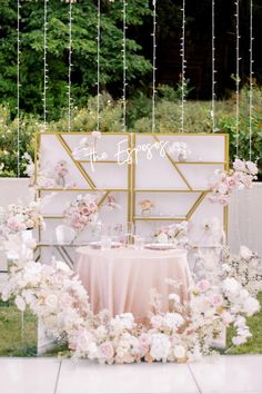 a table set up with pink and white flowers