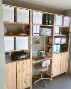 a home office with wooden shelving and white bins