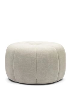 a white round ottoman sitting on top of a floor