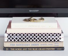 three books stacked on top of each other in front of a computer keyboard and monitor