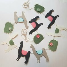 a bunch of llamas are hanging from a string on a table with other items