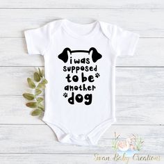 a baby bodysuit with the words i was supposed to be another dog on it