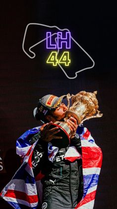 a man holding up a trophy in front of a neon sign that reads,'leth 4 / 4 '