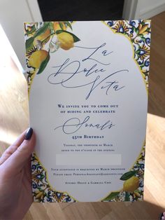 a person holding up a wedding card in their hand