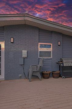 a house with a hot tub and chairs on the front porch at sunset or dawn