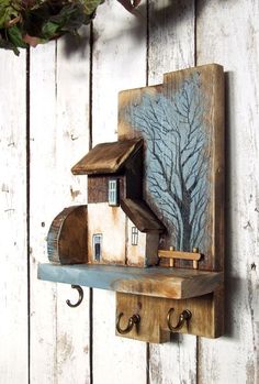 a wooden shelf with a house and tree on it