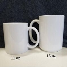 two white coffee mugs sitting next to each other on a table with measurements for them